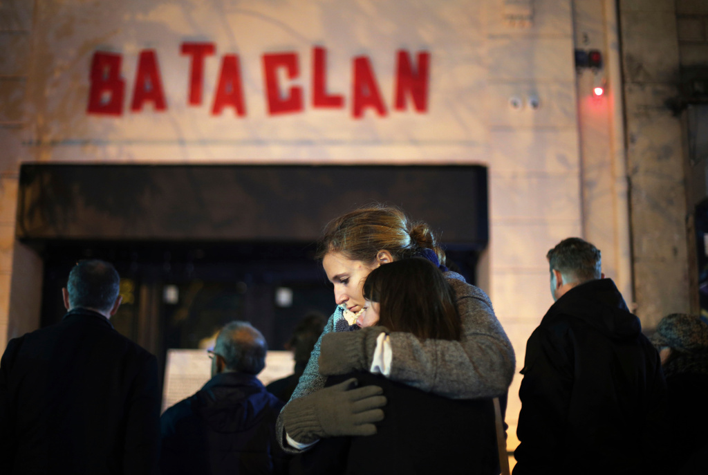 FILE - Women hug in front of the Bataclan concert hall in Paris on Nov. 13, 2016 . (AP Photo/Thibault Camus, File)