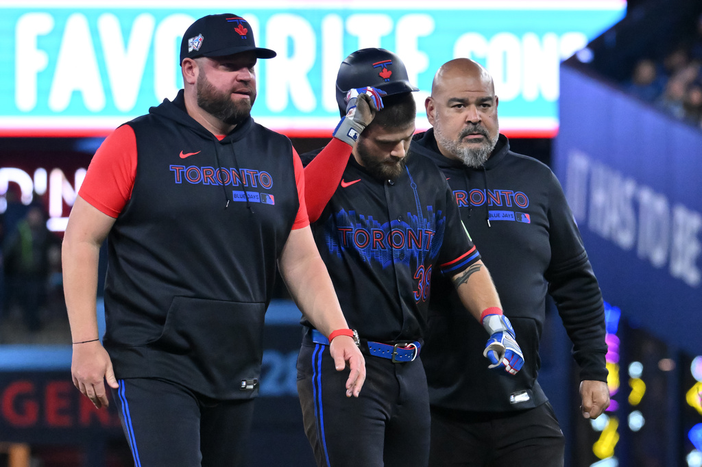 Toronto Blue Jays' Nathan Lukes, centre, leaves the game after getting injured sliding into second base against the Cleveland Guardians in first inning of a baseball game in Toronto on Friday, April 24, 2026. (Jon Blacker/The Canadian Press via AP)