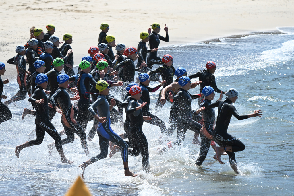 Competitors run into the water during the start of the Elite Women's final of the World Triathlon Championships in Wollongong, Australia, Sunday, Oct. 19, 2025. (Dean Lewins/AAPImage via AP)