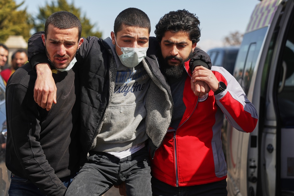 A Syrian government combatant is assisted by Red Crescent paramedics after being released in a prisoner exchange between Syrian government forces and Druze militiamen in Sweida province, Syria, Thursday, Feb. 26, 2026. (AP Photo/Ghaith Alsayed)