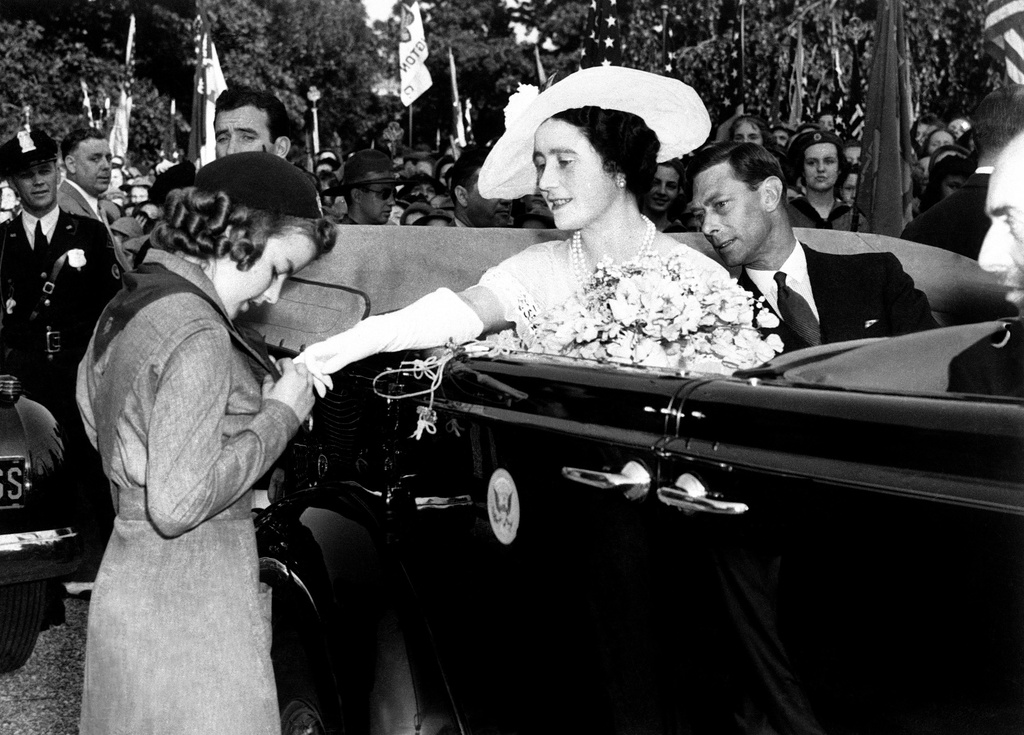 FILE - In this June 8, 1939 file photo, Queen Elizabeth asks Girl Scout Leah Burket about a medal just after the girl had presented her Majesty with a bouquet on behalf of the 3,000 Girl Scouts who paraded on the lawn of the White House in Washington. King George VI is at right. It's been 100 years since Juliette Gordon Low recruited the first scouts in Georgia. Low's original registration book from March of 1912 shows 102 recruits. Now there are 2.3 million active Girl Scouts nationwide. (AP Photo/File)