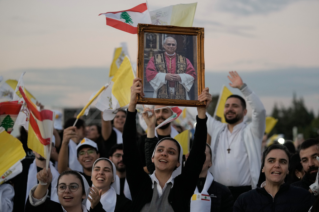 Youth carry a picture of Pope Leo XIV ahead of his visit to Bkerki, the seat of the Maronite church, Lebanon, Monday, Dec. 1, 2025. (AP Photo/Bilal Hussein)