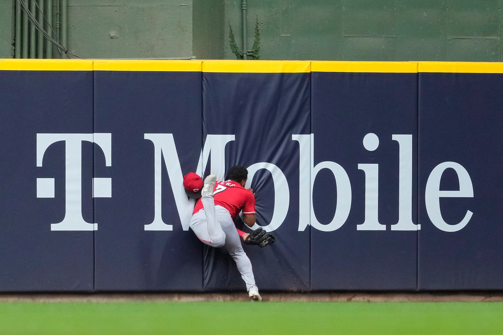 Cincinnati Reds' Dane Myers runs into the wall after making a catch during the fourth inning of a baseball game against the Milwaukee Brewers, Monday, June 29, 2026, in Milwaukee. (AP Photo/Aaron Gash)