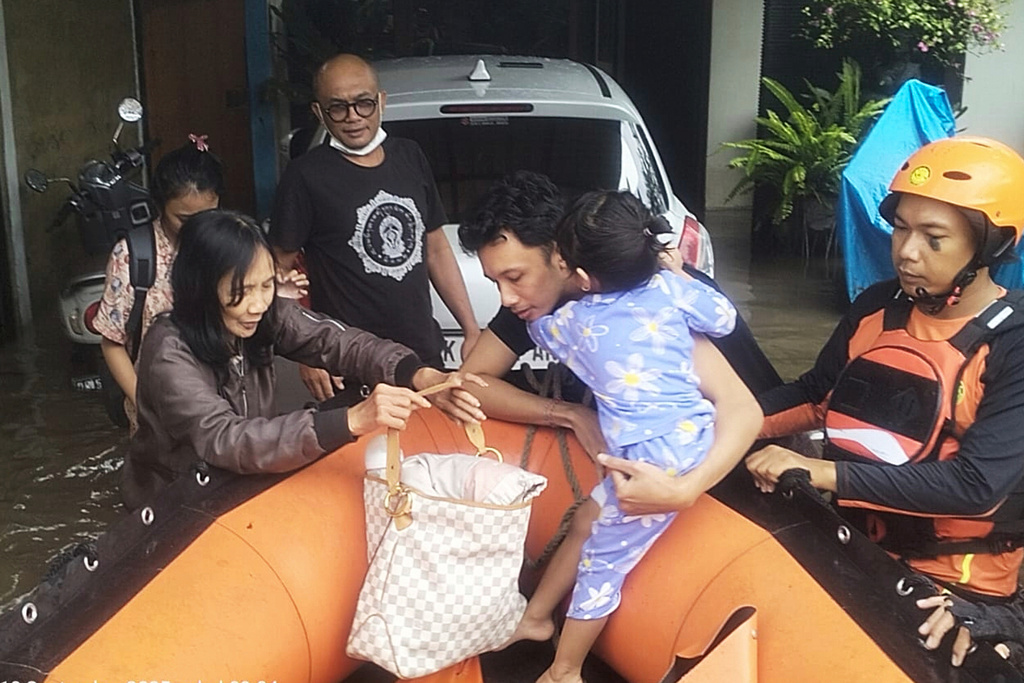 In this photo released by Indonesia's National Search and Rescue Agency (BASARNAS), rescuers evacuate residents from their flooded home in Denpasar, Bali, Indonesia Wednesday, Sept. 10, 2025. (BASARNAS via AP)