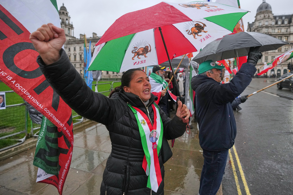 Protester Adeleh Tavakoli, left, demonstrates outside the House of Parliament, in London, Tuesday, Jan. 13, 2026. (AP Photo/Kin Cheung)