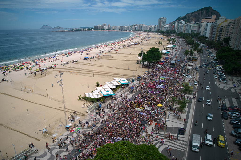 People march marking International Women's Day on Copacabana beach, in Rio de Janeiro, Sunday, March 8, 2026. (AP Photo/Silvia Izquierdo)