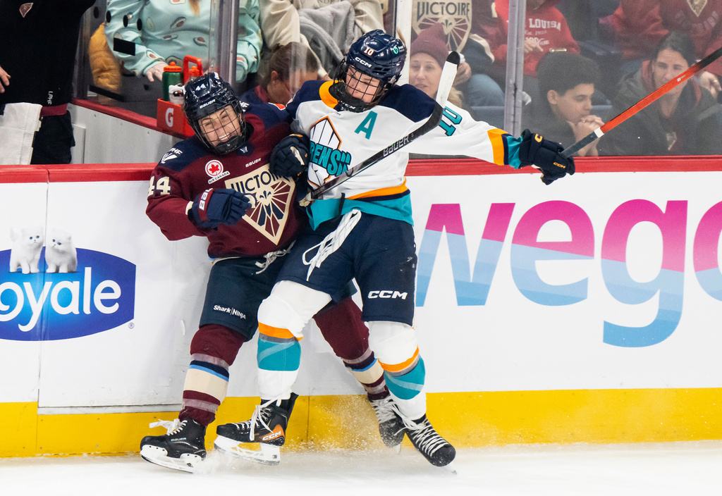 Montréal Victoire's Amanda Boulier (44) and New York Sirens' Sarah Fillier (10) collide on the boards during the first period of a PWHL hockey game, in Laval, Quebec, Tuesday, Nov. 25, 2025. (Christopher Katsarov/The Canadian Press via AP)