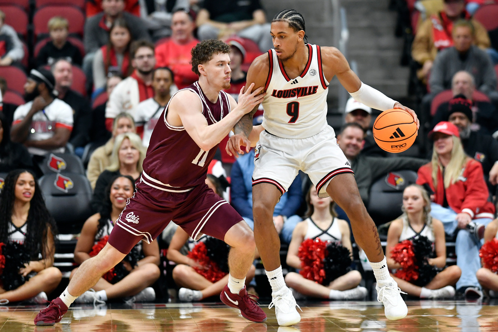 Louisville forward Khani Rooths (9) attempts to get past Montana guard Grant Kepley (11) during the first half of an NCAA college basketball game in Louisville, Ky., Saturday, Dec. 20, 2025. (AP Photo/Timothy D. Easley)