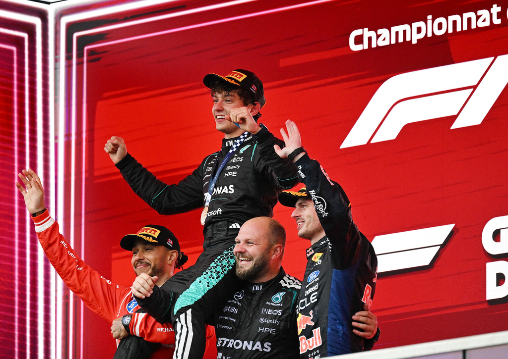 First-place finisher Mercedes driver Kimi Antonelli, top, of Italy, is held aloft by second-place finisher Ferrari driver Lewis Hamilton, left, of Britain, and Mercedes senior composite technician Dean Hale, second from right, as third-place finisher Red Bull Racing driver Max Verstappen, right, of the Netherlands, joins them following the F1 Canadian Grand Prix auto race in Montreal, Sunday, May 24, 2026. (Graham Hughes/The Canadian Press via AP)