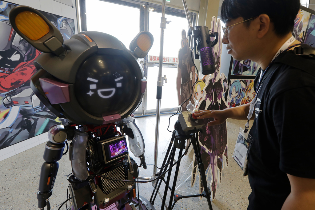 A man communicates with an ASUS Character Virtual Assistant, ROG Omni system during the AI EXPO in Taipei, Taiwan, Wednesday, March 25, 2026. (AP Photo/Chiang Ying-ying)