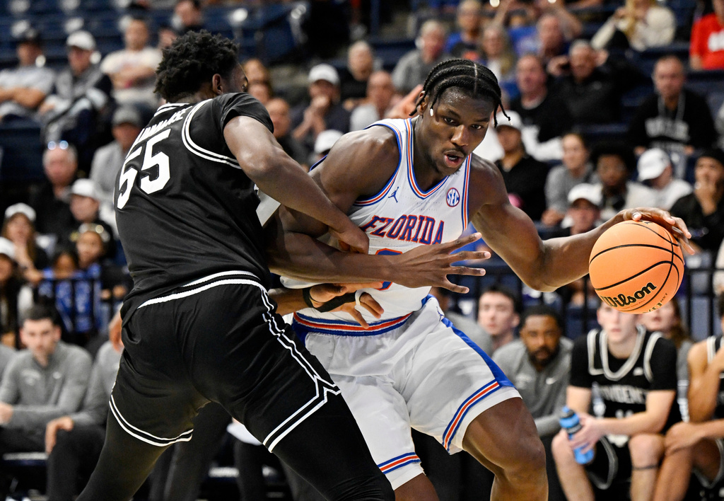 Florida center Rueben Chinyelu, right, drives against Providence forward Oswin Erhunmwunse (55) during the first half of an NCAA college basketball game in the Rady Children's Invitational tournament Friday, Nov. 28, 2025, in San Diego. (AP Photo/Denis Poroy)
