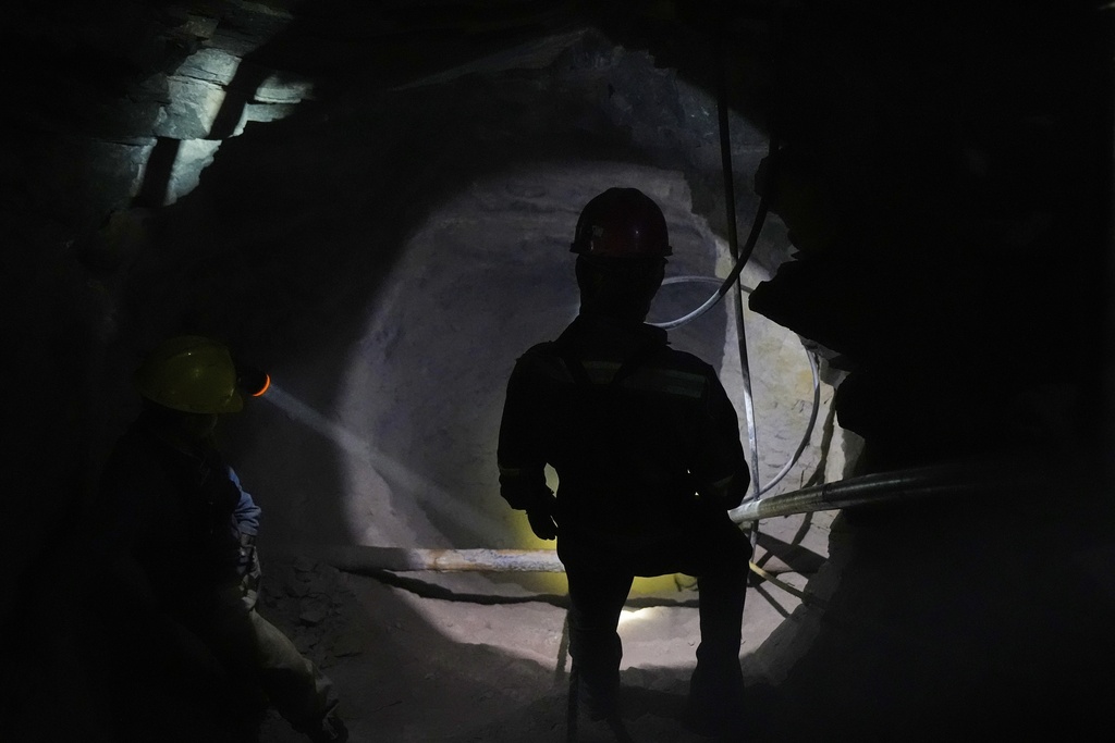 A miner lights up one of the caverns so that his colleagues can see the way out San Joaquin, Mexico, Tuesday, Aug. 19, 2025. (AP Photo/Fernando Llano)