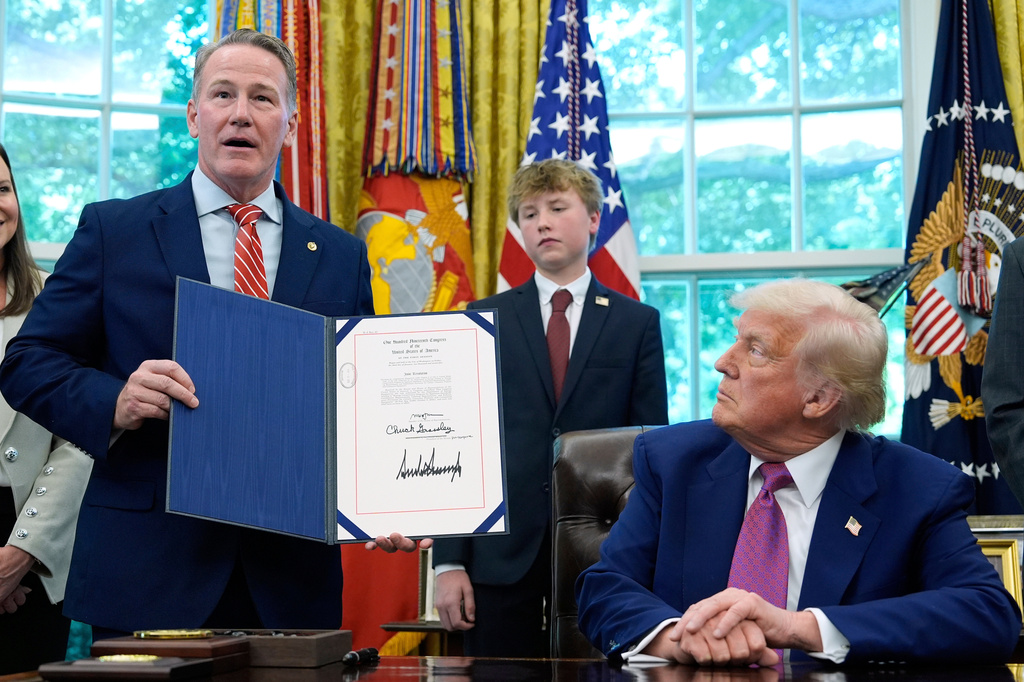 FILE - President Donald Trump listens as Sen. Jon Husted, R-Ohio, speaks while holding up a signed resolution in the Oval Office of the White House, May 9, 2025, in Washington. (AP Photo/Alex Brandon, File)