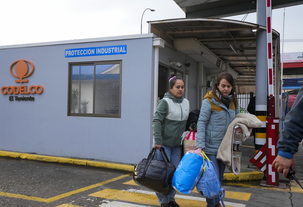 Relatives of a missing miner arrive to the offices of Codelco, operators of El Teniente copper mine, where a cave-in killed one worker and trapped five others underground, halting operations in Rancagua, Chile, Saturday, Aug. 2, 2025. (AP Photo/Esteban Felix)