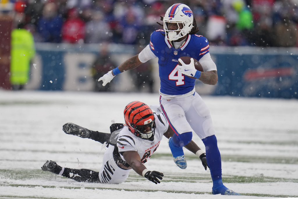Buffalo Bills running back James Cook III (4) runs with the ball past Cincinnati Bengals linebacker Barrett Carter (49) during the second half of an NFL football game, Sunday, Dec. 7, 2025, in Orchard Park, N.Y. (AP Photo/Gene J. Puskar)