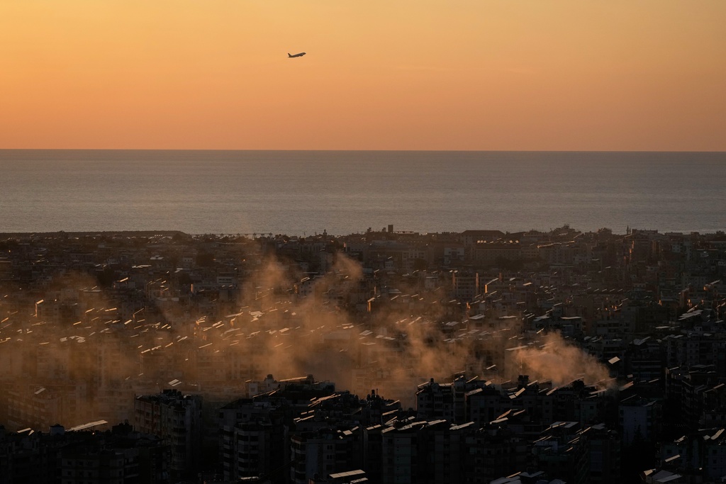 A plane takes off from the Beirut–Rafic Hariri International Airport as smoke from an earlier Israeli airstrike still rises in Dahiyeh, Beirut's southern suburbs, Lebanon, Thursday, March 5, 2026.(AP Photo/Hussein Malla)