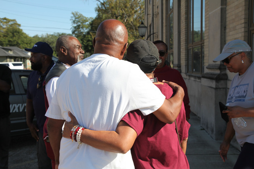 Friends and family of victims of a homecoming shooting embrace in downtown Leland, Miss., Saturday, Oct. 11, 2025. (AP Photo/Katie Adkins) Friends and family of victims of a homecoming shooting embrace in downtown Leland, Miss., Saturday, Oct. 11, 2025. (AP Photo/Katie Adkins)