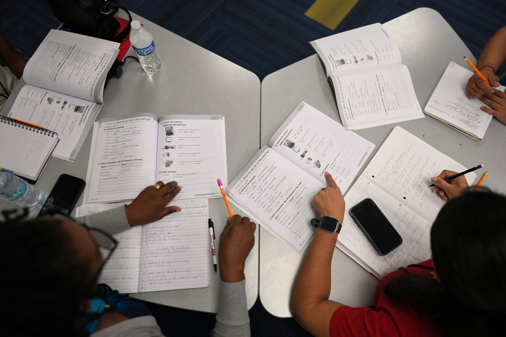 Immigrants trying to learn the English language do a workbook exercise as they participate in ESOL class offered by Catholic Charities of Central Florida, Tuesday, Aug. 19, 2025, in Orlando, Fla. (AP Photo/Rebecca Blackwell)