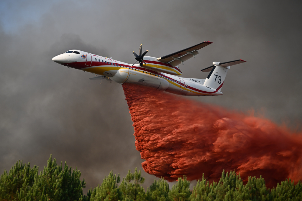 FILE - A plane releases fire retardant as it flies over a forest near Blagon, during wildfires in southwestern France, July 29, 2026. (AP Photo/Emma Da Silva, File)