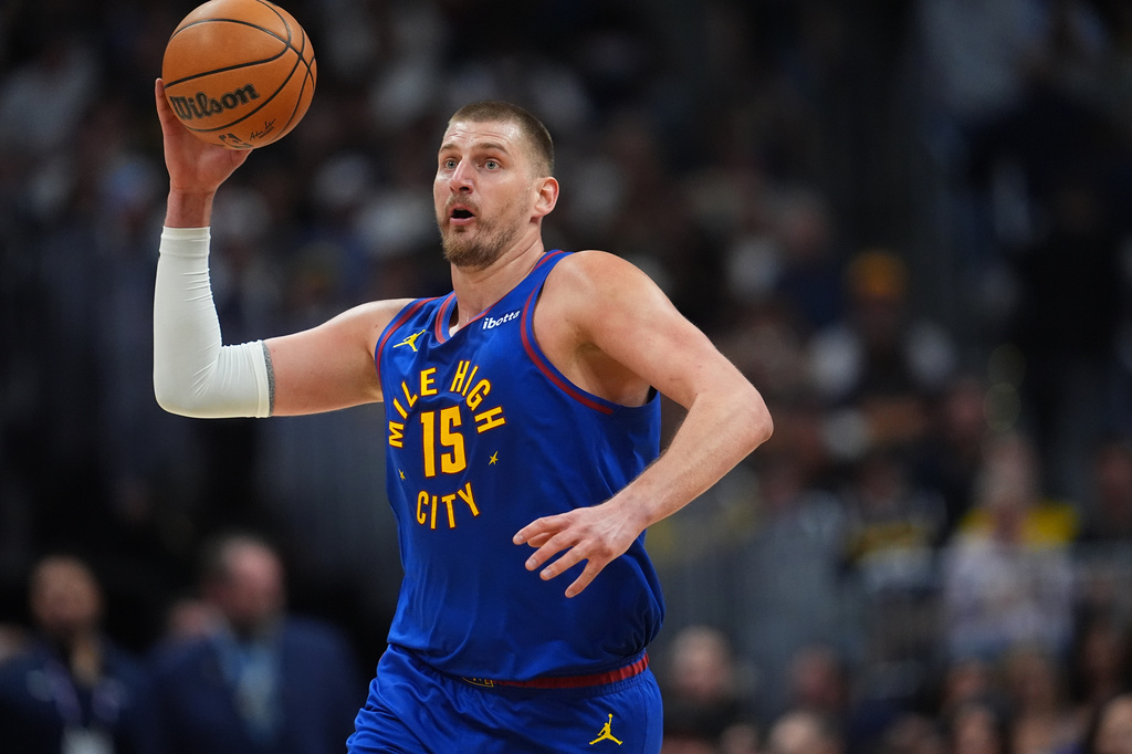 Denver Nuggets center Nikola Jokić thorws the ball in an attempt to make a basket as time runs out in the first quarter of an NBA basketball game against the Golden State Warriors Sunday, March 29, 2026, in Denver. (AP Photo/David Zalubowski)