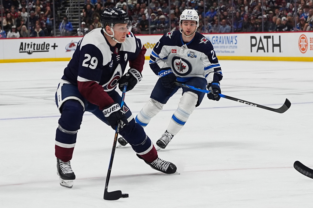 Colorado Avalanche center Nathan MacKinnon (29) drives past Winnipeg Jets right wing Isak Rosen, right, in the first period of an NHL hockey game Saturday, March 28, 2026, in Denver. (AP Photo/David Zalubowski)