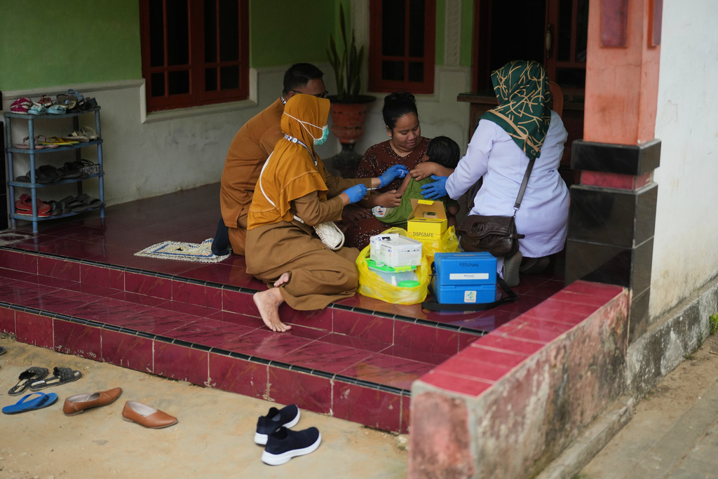 Health workers administer a measles vaccine to a child during a house-to-house campaign following an outbreak in Sumenep on Madura Island, Indonesia, Monday, Sept. 8, 2025. (AP Photo/Dita Alangkara)