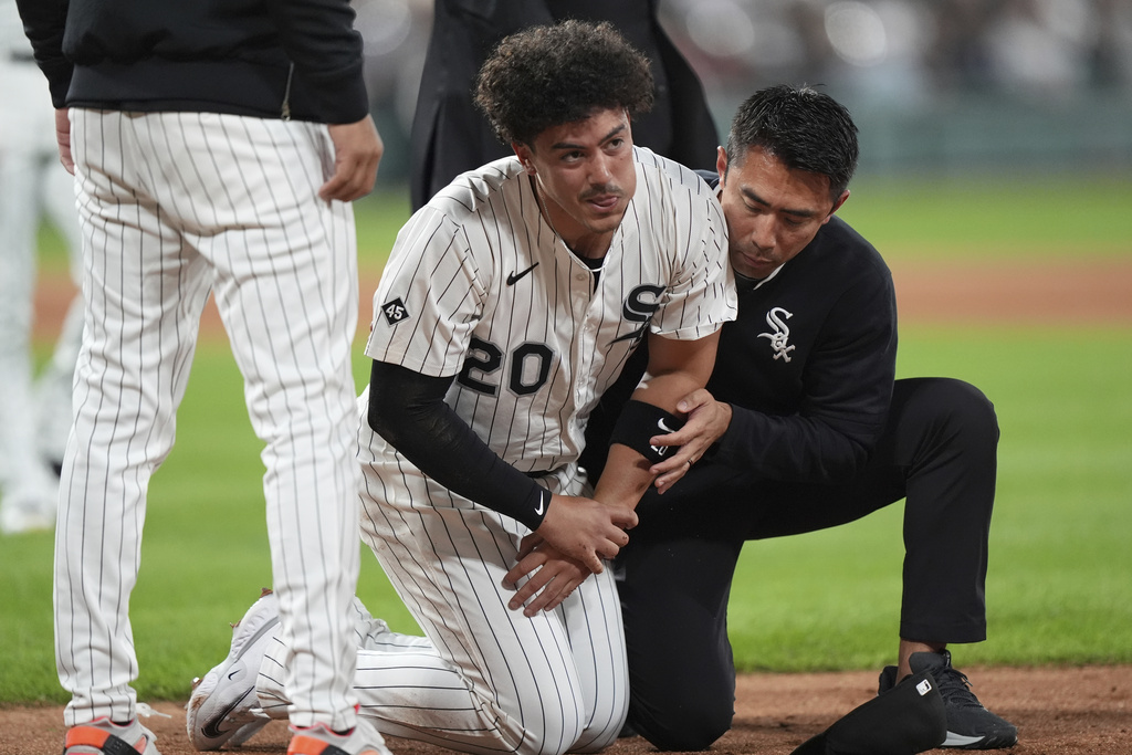 Chicago White Sox first baseman Miguel Vargas is helped by a team trainer after a injury during the fifth inning of a baseball game against the New York Yankees in Chicago, Thursday, Aug. 28, 2025. (AP Photo/Nam Y. Huh)
