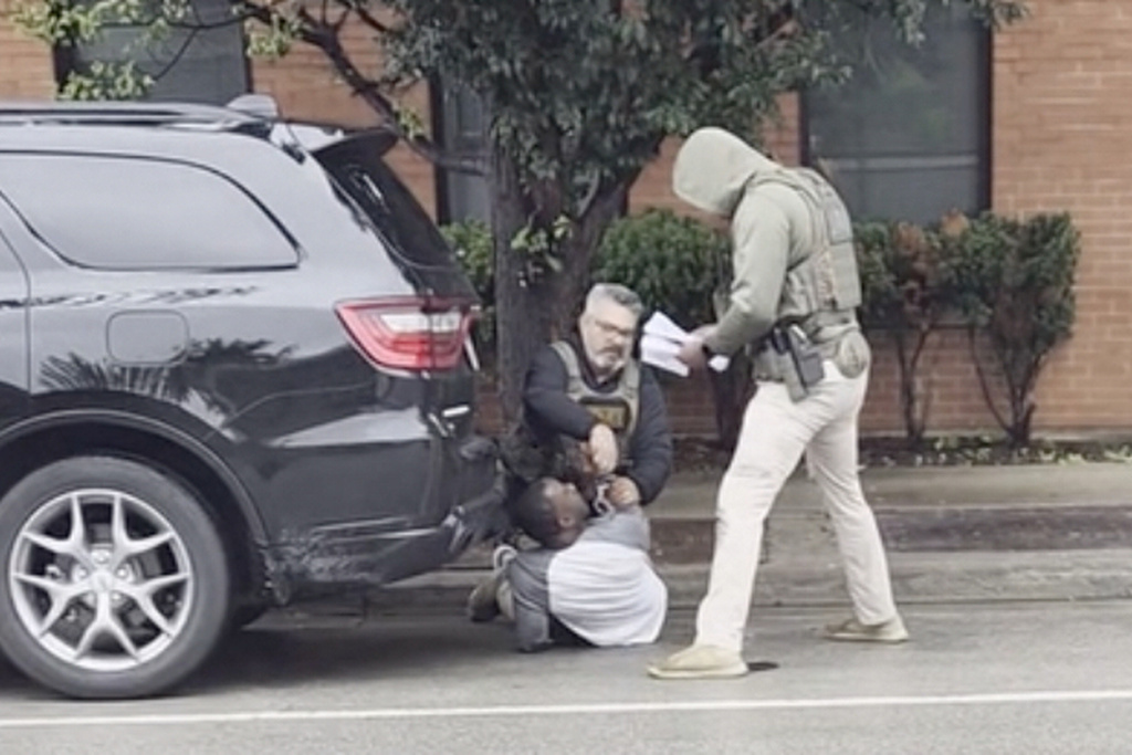 This image taken from video shows a federal officer removing handcuffs from a U.S. citizen after immigration enforcement agents mistook him for a fugitive, Sunday, Sept. 20, 2026, in Evanston, Ill. (Michael Lipson via AP)