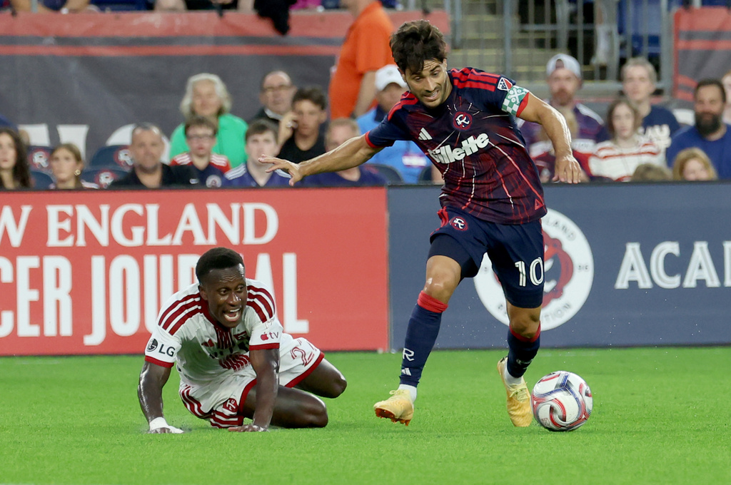 Toronto FC's Richie Laryea, left, reacts after New England Revolution's Carles Gil (10) steals the ball in the first half of an MLS soccer match, Wednesday, July 22, 2026, in Foxborough, Mass. (AP Photo/Mark Stockwell)