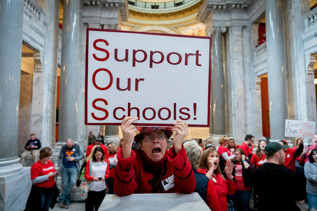 FILE - Karen Schwartz, a teacher at Phoenix School of Discovery in Louisville, stands with other teachers and their supporters to protest perceived attacks on public education on March 12, 2019, in Frankfort, Ky. (AP Photo/Bryan Woolston, File)