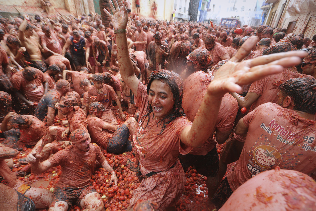 Revelers throw tomatoes at each other during the annual "Tomatina" tomato fight fiesta, in the village of Bunol near Valencia, Spain, Wednesday, Aug. 27, 2025. (AP Photo/Alberto Saiz)