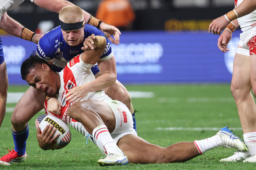 Dragons Luciano Leilua is tackled by Bulldogs Bailey Hayward, top, during the Australia National Rugby League game between the Canterbury Bulldogs and the St George-Illawarra Dragons in Las Vegas, Saturday, Feb. 28, 2026. (AP Photo/Ian Maule)