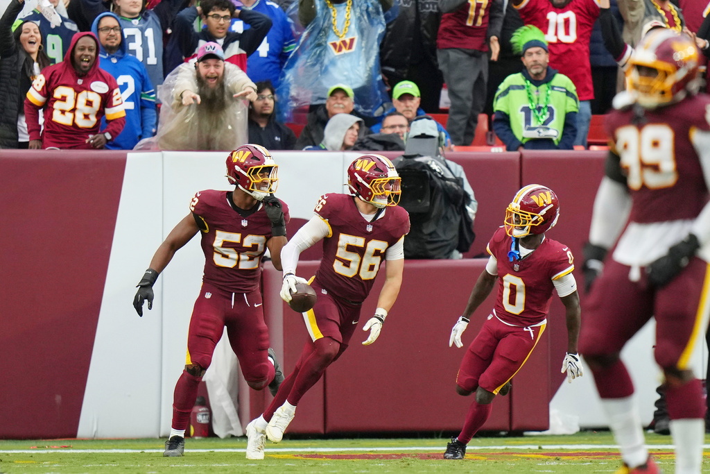 Washington Commanders linebacker Kain Medrano (56) celebrating his touchdown with teammates linebacker Sonny Styles (52) and cornerback Mike Sainristil (0) during the second half of an NFL football game against Seattle Seahawks, Sunday, Sept. 27, 2026 in Landover, Md. (AP Photo/Stephanie Scarbrough)