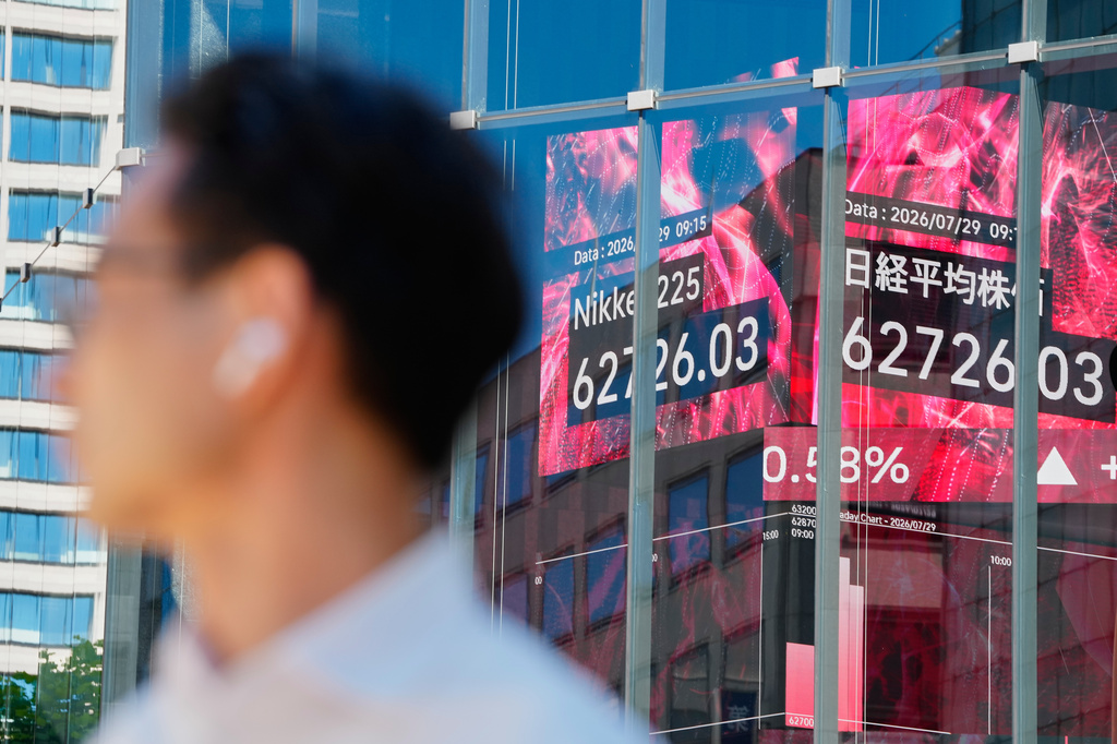 A person stands near an electronic board showing Japan's Nikkei index at a securities firm Wednesday, July 29, 2026, in Tokyo. (AP Photo/Eugene Hoshiko)