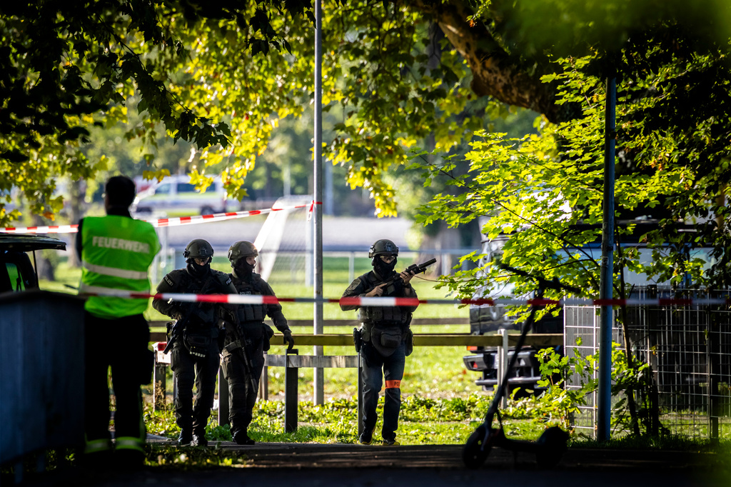 Police officers secure the area around the Schachen horse racing track following a shooting at a rave, in Aarau, Switzerland, Sunday Aug. 30, 2026. (Michael Buholzer/Keystone via AP)