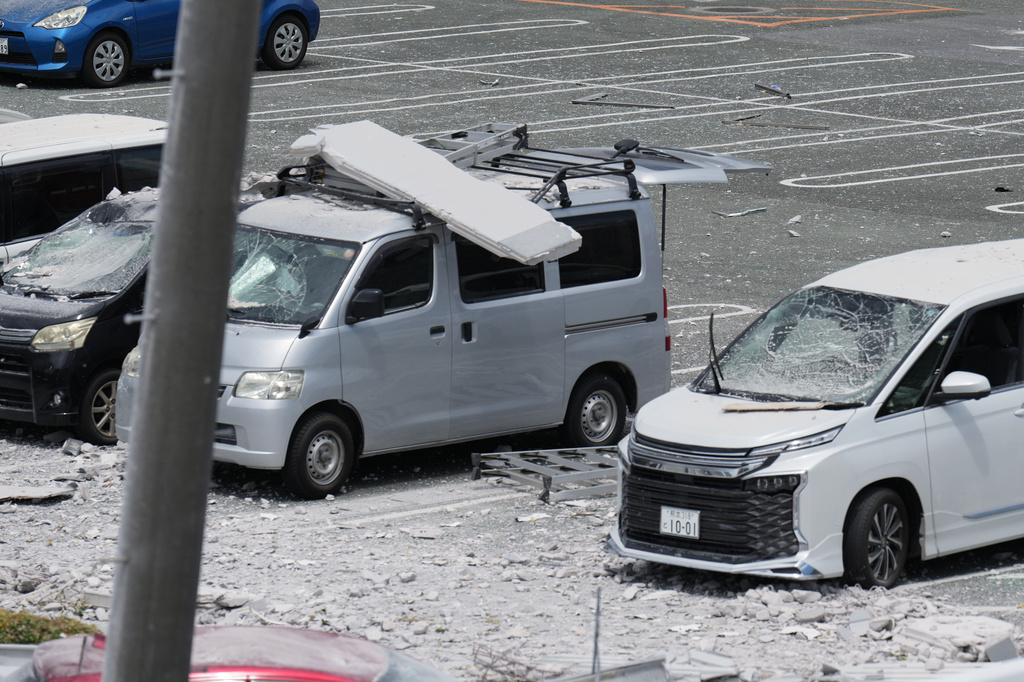 Damaged cars are seen in a parking lot at AEON Mall, which was damaged by an explosion following an earthquake, in Kashima, Kumamoto Prefecture, southern Japan, Wednesday, July 29, 2026. (AP Photo/Hiro Komae)