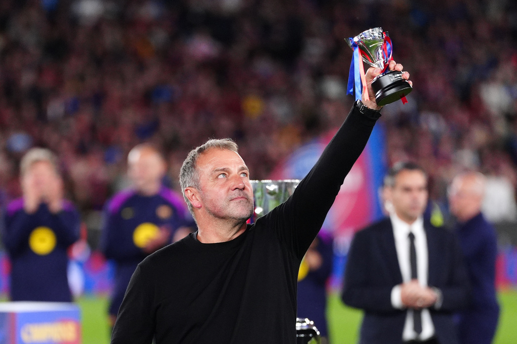 Barcelona head coach Hansi Flick lifts his award to the sky celebrating after defeating Real Madrid 2-0 to win the Spanish La Liga soccer championship with three rounds to spare, in Barcelona, Spain, Sunday, May 10, 2026. (AP Photo/Joan Mateu Parra)
