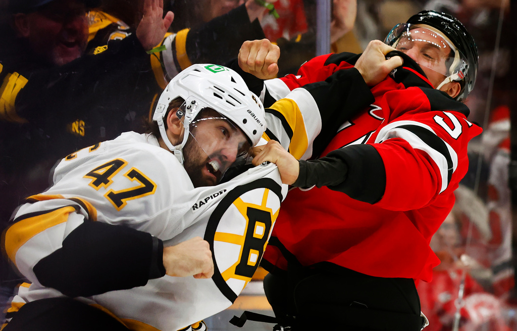 Boston Bruins' Mark Cotter (47) and New Jersey Devils' Brenden Dillon (5) fight during the first period of an NHL hockey game, Monday, March 16, 2026, in Newark, N.J. (AP Photo/Noah K. Murray)