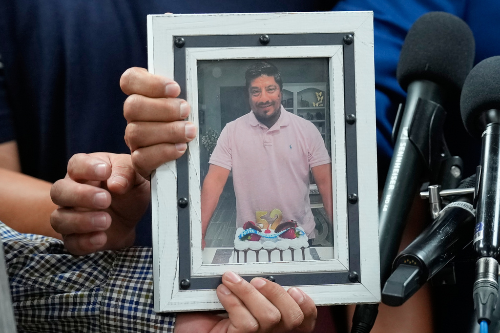 Ronaldo Salgado and Lorenzo Jr., sons of Lorenzo Salgado Araujo, hold a photograph of their father during a news conference Wednesday, July 8, 2026, in Houston. (AP Photo/David J. Phillip)
