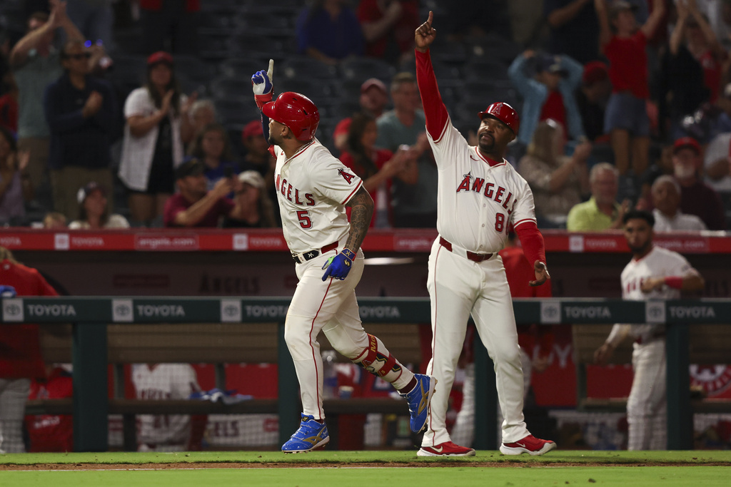 Los Angeles Angels' Yoán Moncada (5) celebrates with third base coach Bo Porter (88) after hitting a home run during the seventh inning of a baseball game against the Minnesota Twins, Tuesday, Sept. 9, 2025, in Anaheim, Calif. (AP Photo/Jessie Alcheh)