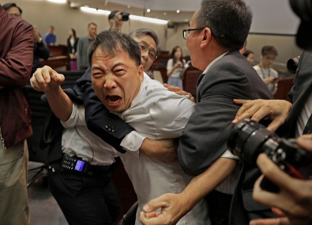 FILE - Pro-democracy lawmaker Wu Chi-wai scuffles with security guards at the Legislative Council in Hong Kong, May 11, 2019, (AP Photo/Vincent Yu, File)