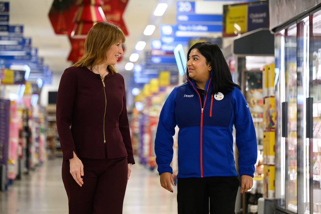 British Chancellor of the Exchequer Rachel Reeves, left, speaks with Tesco Mobile manager Ashna Mehta during a visit to a branch of the Tesco supermarket chain, in London, Wednesday Nov. 19, 2025 in. (Leon Neal/Pool Photo via AP)