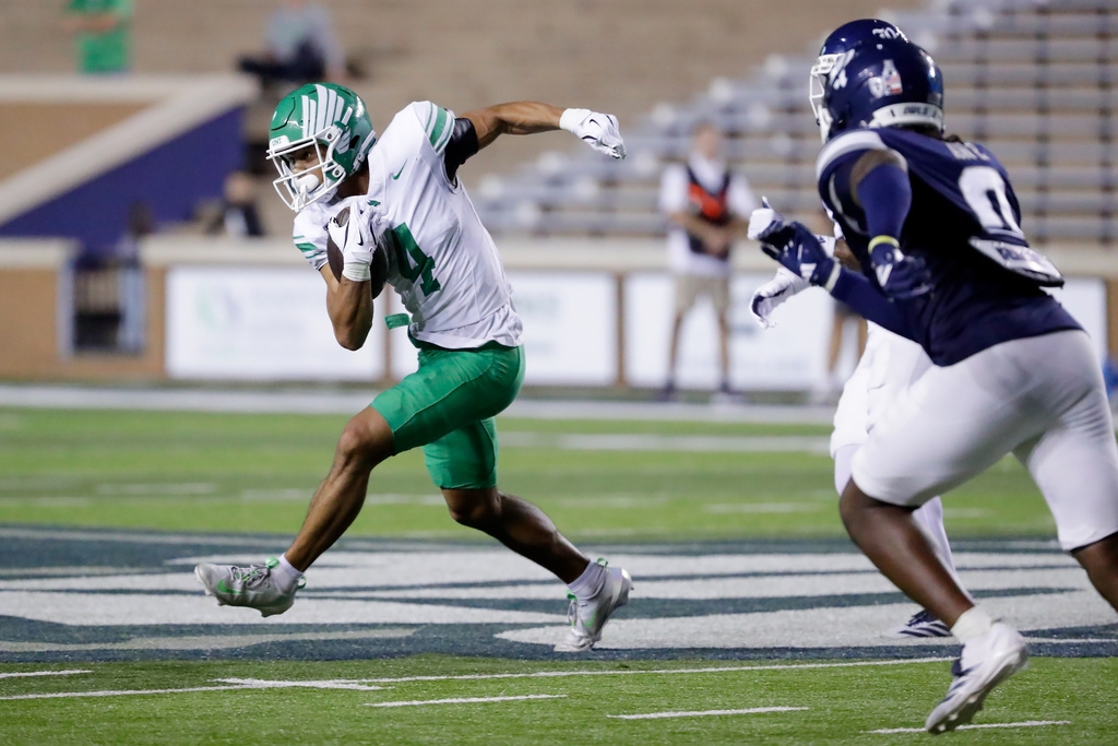 North Texas wide receiver Cameron Dorner, left, outruns safety Peyton Stevenson, center, and linebacker Andrew Awe, right, during the second half of an NCAA college football game Saturday, Nov. 22, 2025, in Houston. (AP Photo/Michael Wyke)