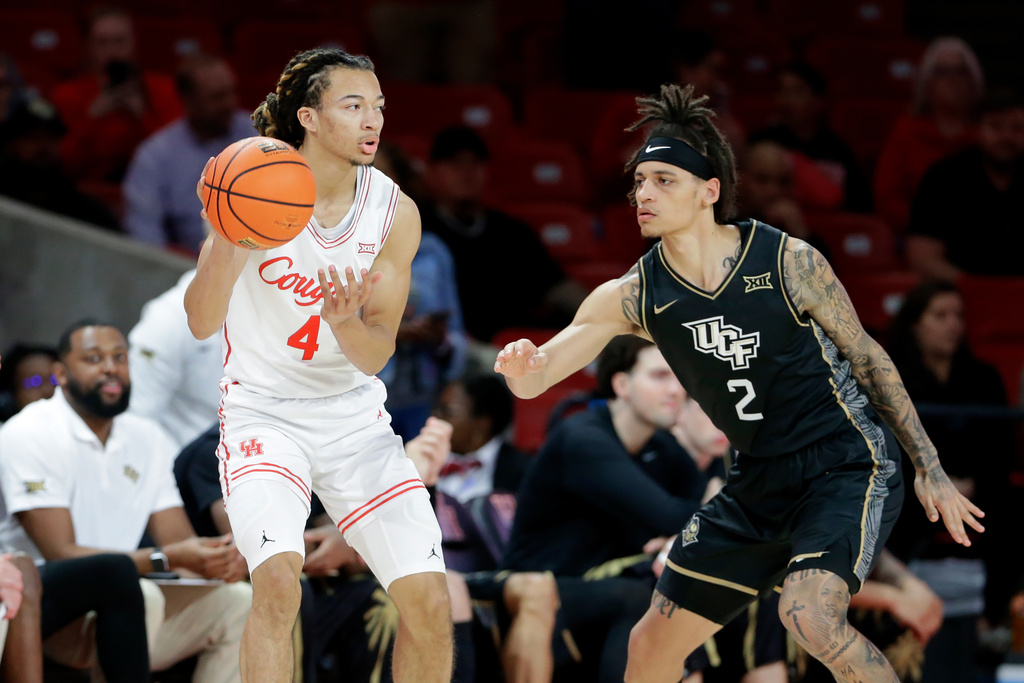 Houston guard Kingston Flemings (4) looks to pass the ball under pressure from Central Florida guard Riley Kugel (2) during the first half of an NCAA college basketball game, Wednesday, Jan., 4, 2026, in Houston. (AP Photo/Michael Wyke)