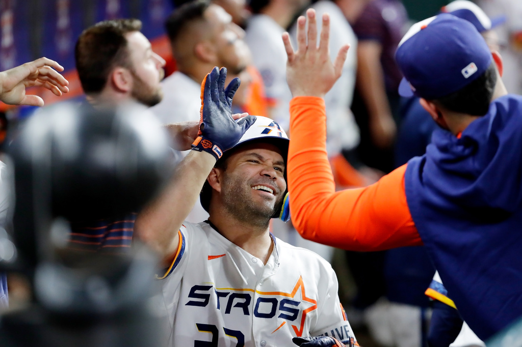 Houston Astros' Jose Altuve, center, collects high-fives in the dugout after his solo home run against the Detroit Tigers during the third inning of a baseball game Monday, June 15, 2026, in Houston. (AP Photo/Michael Wyke)