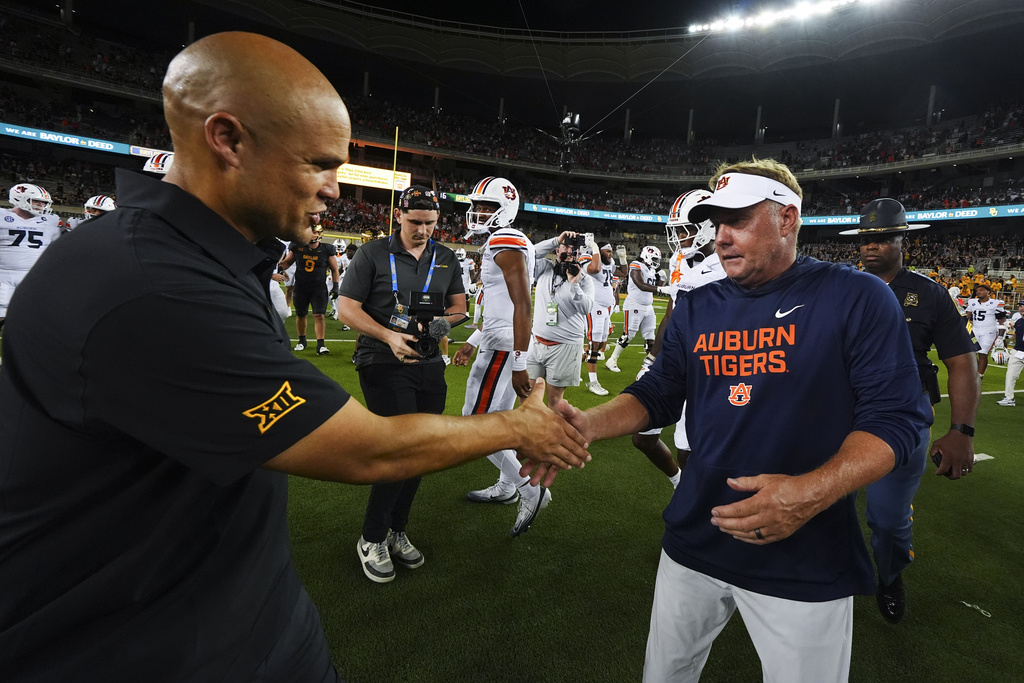 Baylor head coach Dave Aranda, left, shakes hands with Auburn head coach Hugh Freeze following an NCAA college football game Friday, Aug. 29, 2025, in Waco, Texas. (AP Photo/Julio Cortez)
