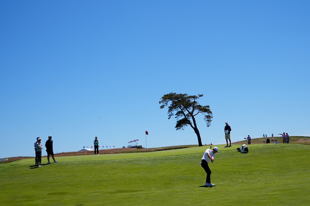 T.K. Kim chips to the green on the 14th hole during a practice round for the U.S. Open golf tournament at Shinnecock Hills Golf Club in Southampton, N.Y., Tuesday, June 16, 2026.(AP Photo/Gerald Herbert)