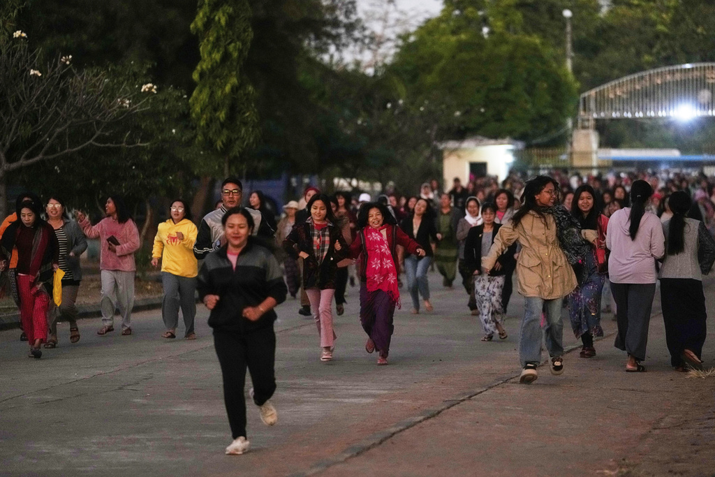 Voters run to cast their ballots at a polling station in Naypyitaw, Myanmar, Sunday, Dec. 28, 2025. (AP Photo/Aung Shine Oo)