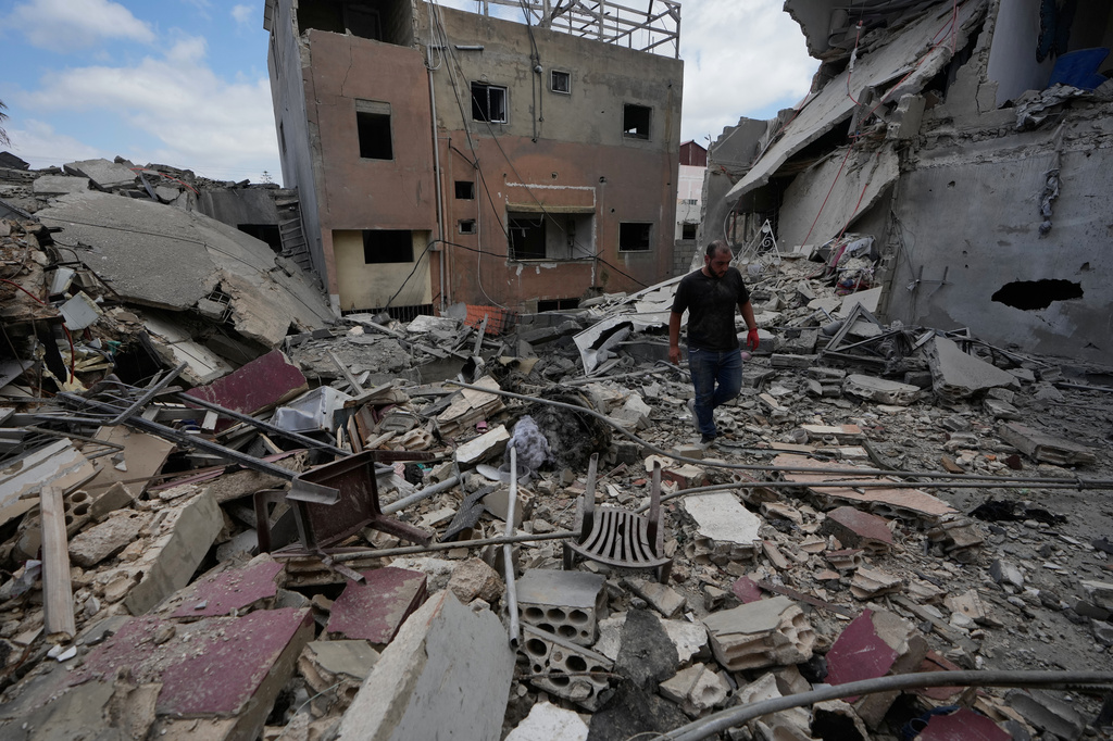 A man walks between destroyed buildings that were hit in Israeli airstrikes in Burj al-Shemali village near the southern port city of Tyre, Lebanon, Tuesday, May 26, 2026. (AP Photo/Mohammed Zaatari)