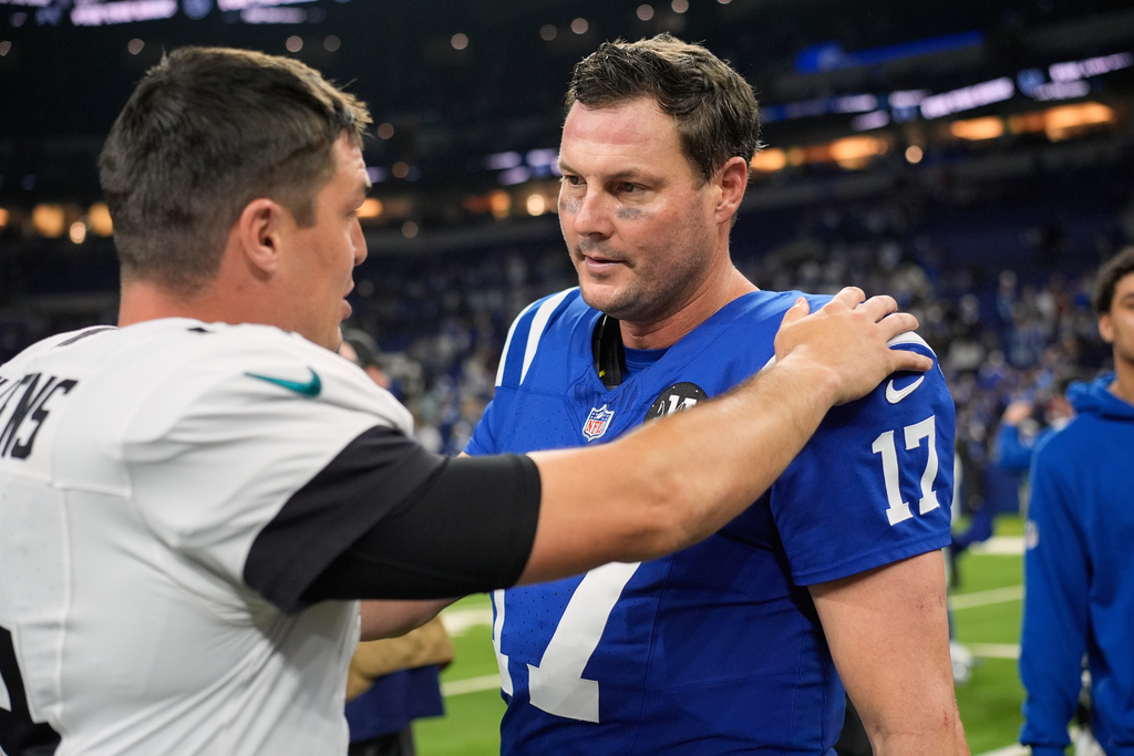 Jacksonville Jaguars quarterback Nick Mullens (14) talks with Indianapolis Colts quarterback Philip Rivers (17) following an NFL football game Sunday, Dec. 28, 2025, in Indianapolis. (AP Photo/Carolyn Kaster)